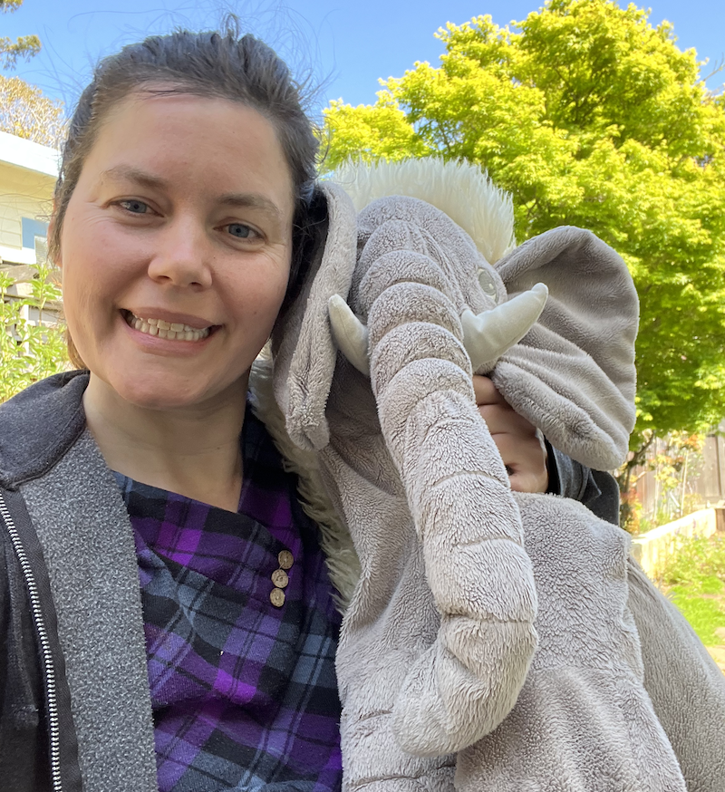 Photo of Pamela smiling with a stuffed elephant